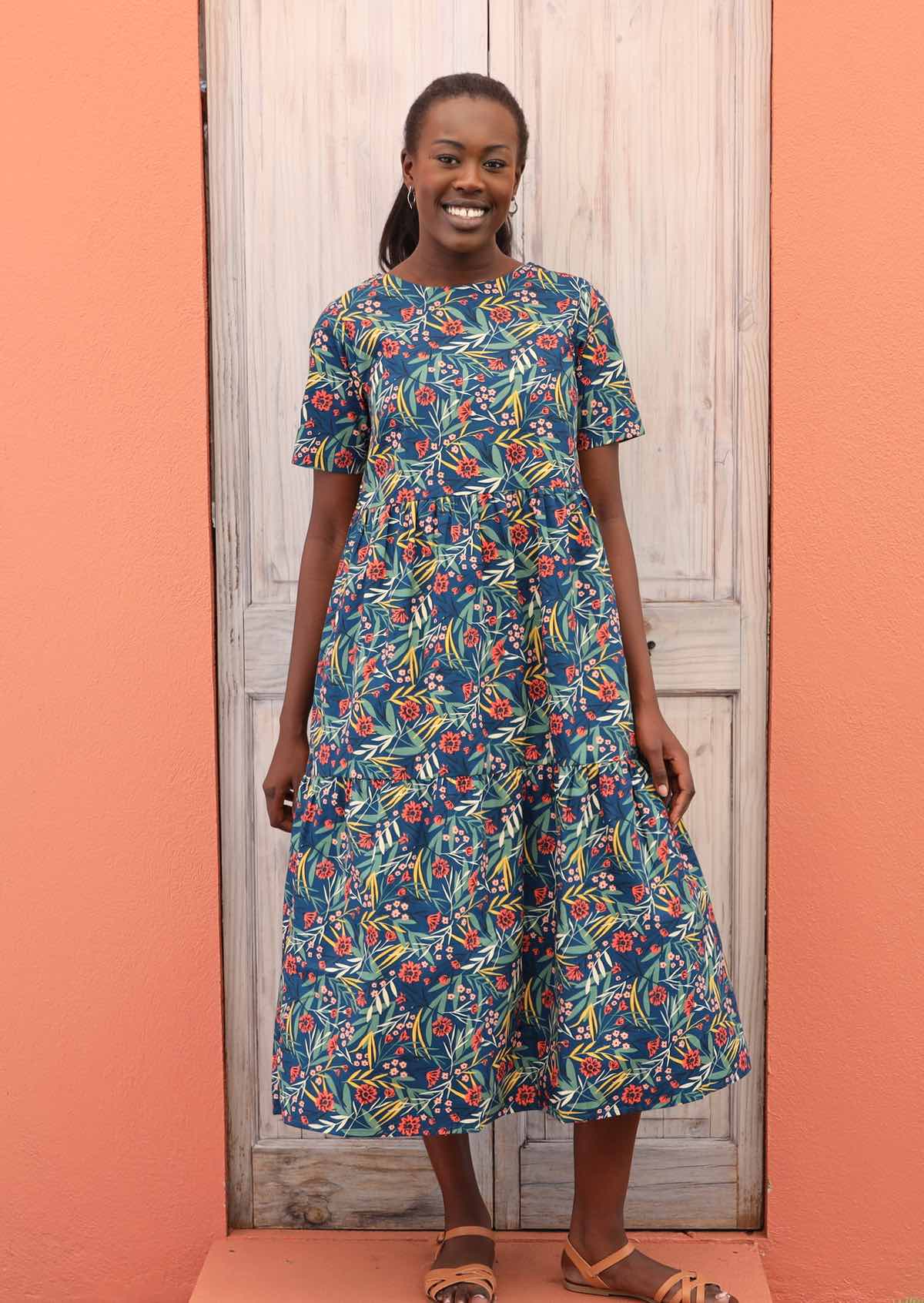 Model wears a three tiered, short sleeve 100% cotton dress. 