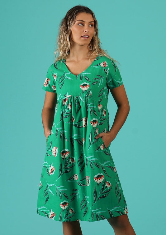 Model wears 100% cotton dress with side pockets with green base and white floral design