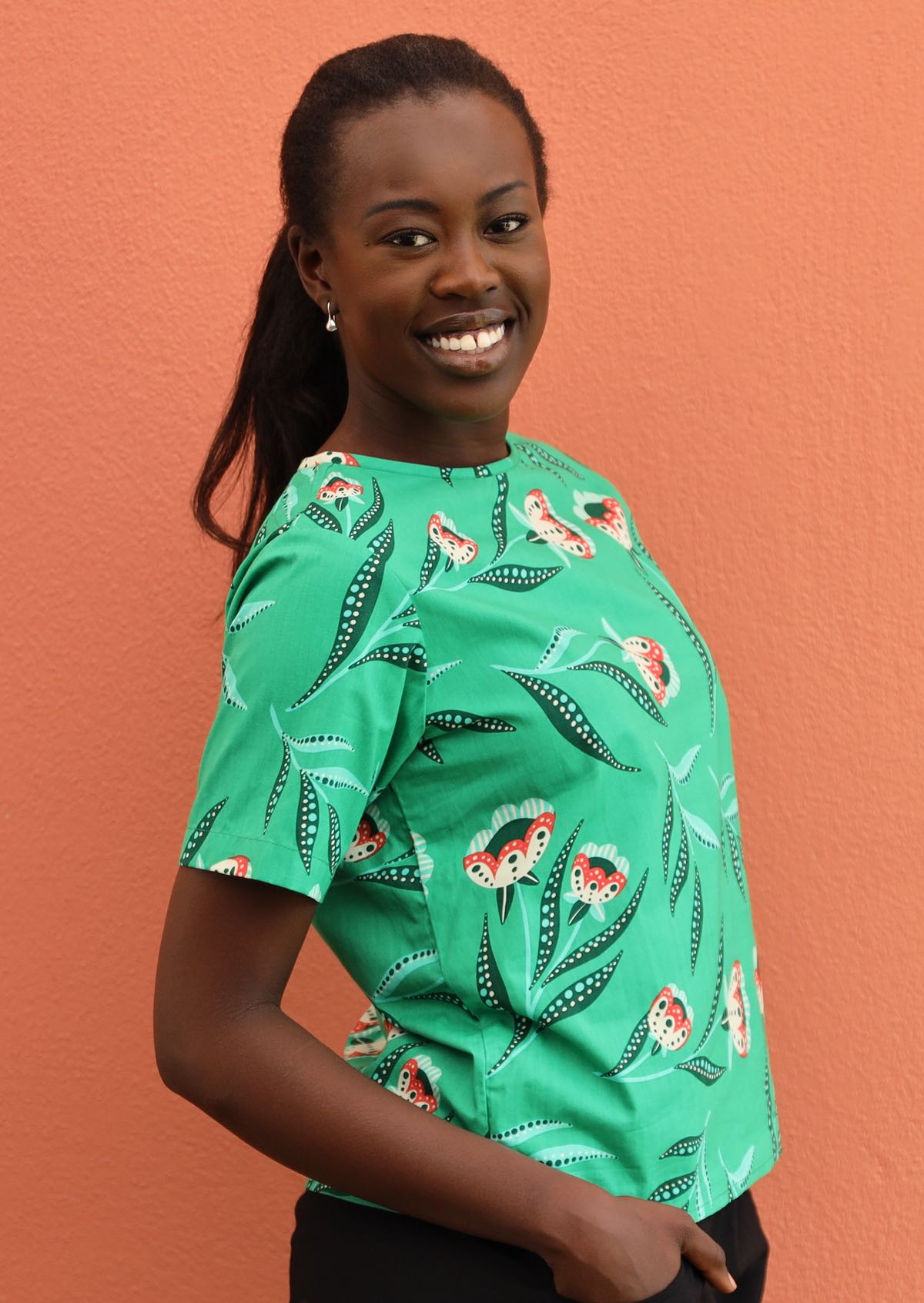 Model wears floral print on bright green base cotton top